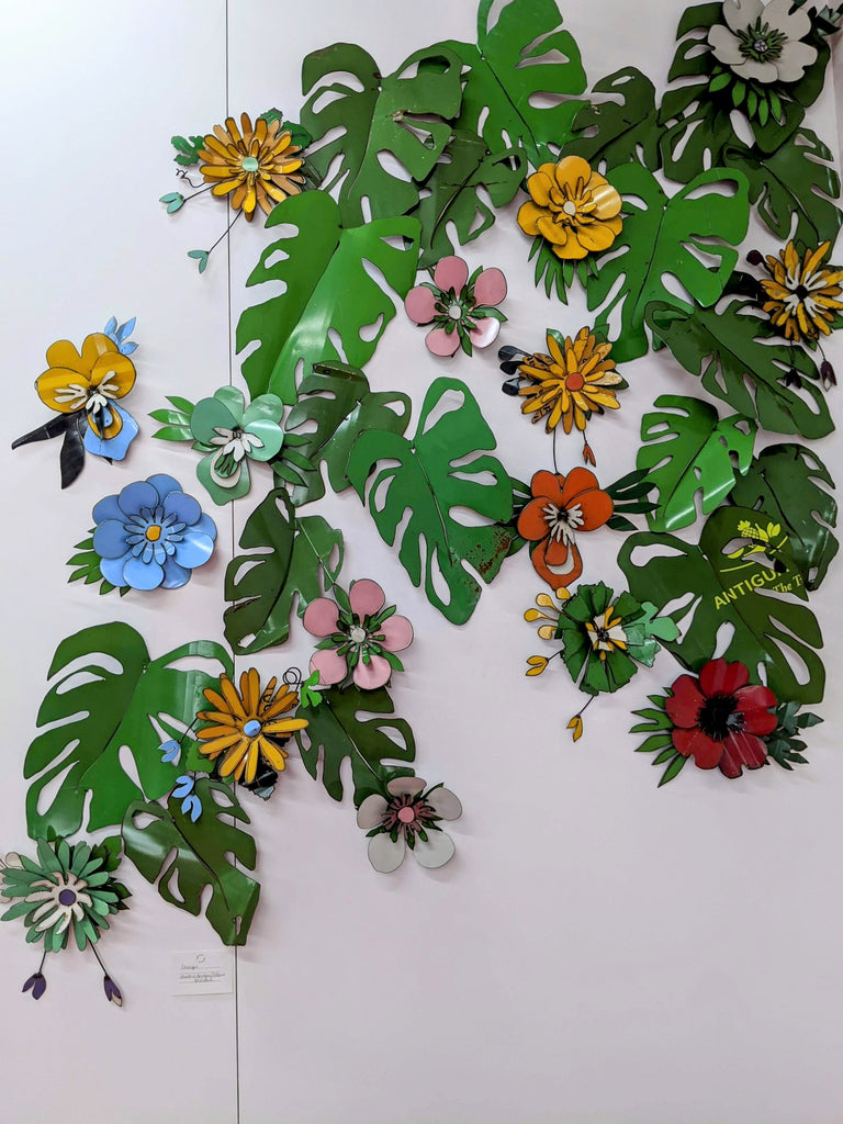 Wall installation of artworks: Corsages and Monstera leaves in Metal Metcalfe's gallery in Havelock North. All made from repurposed 44-gallon drums.
