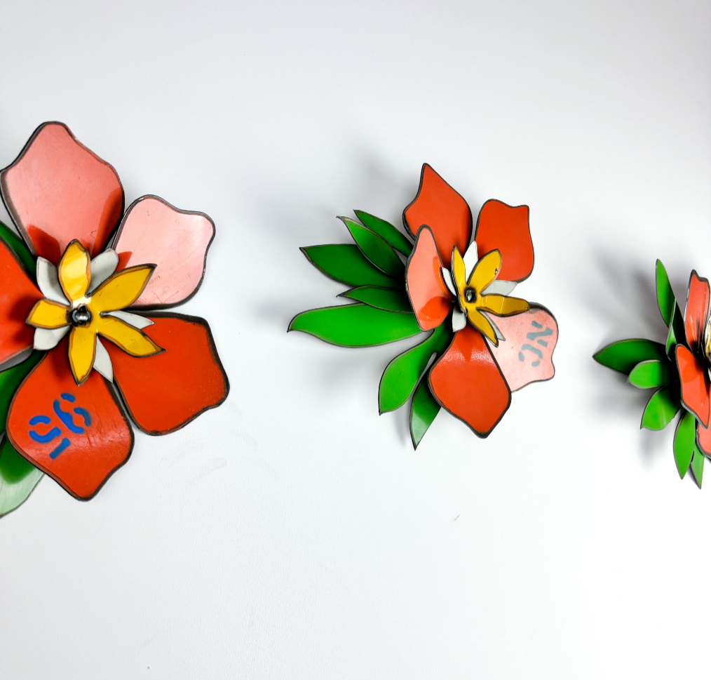 three orange frangipani corsages made from 44-gallon drums by metal metcalfe